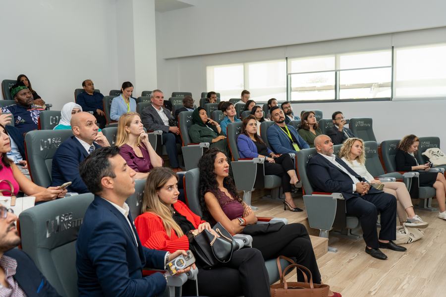 A seated audience at SEE Institute, faces turned towards a speaker off frame