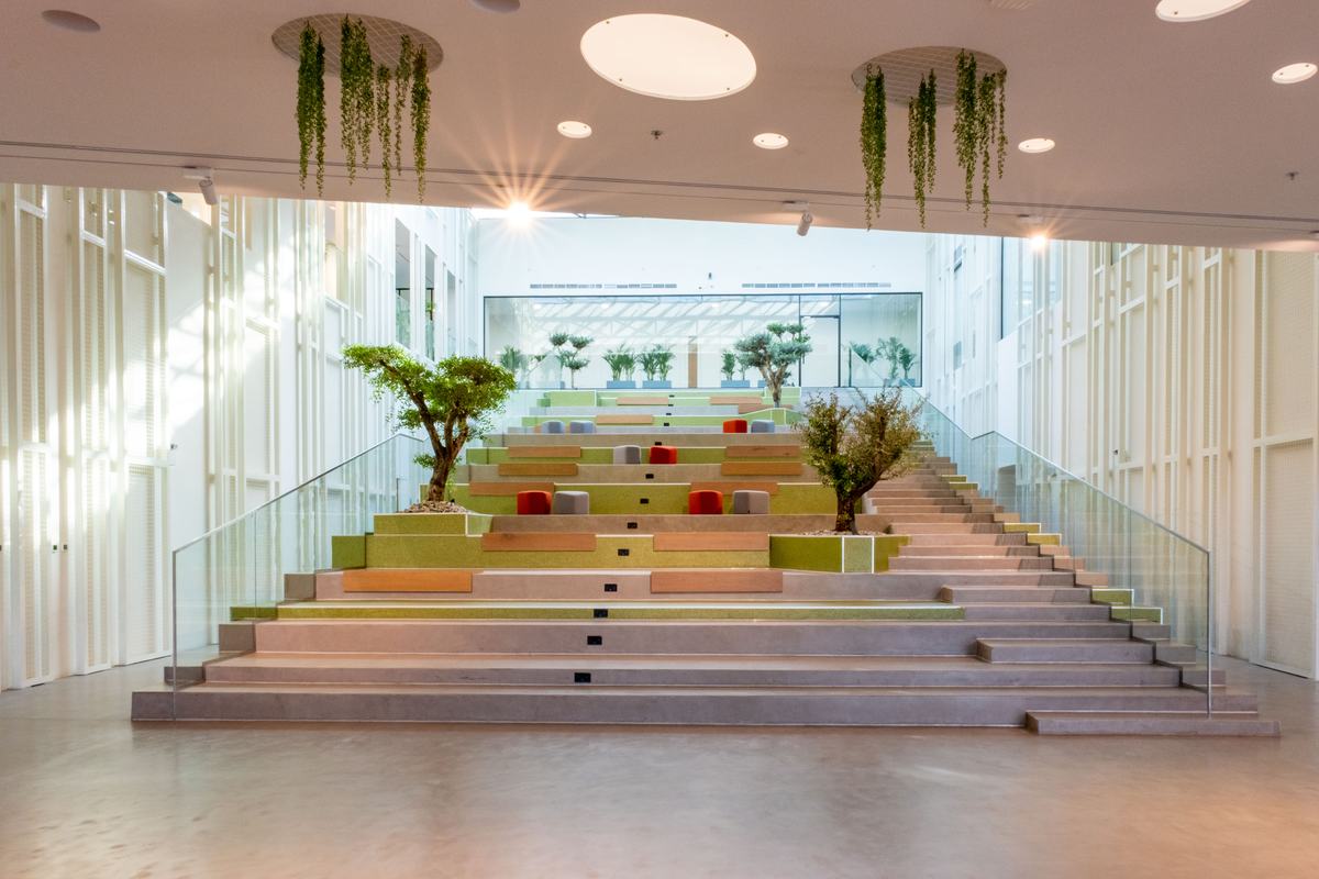 The SEE Institute atrium, a wide planted staircase of terraced seating under a glass roof