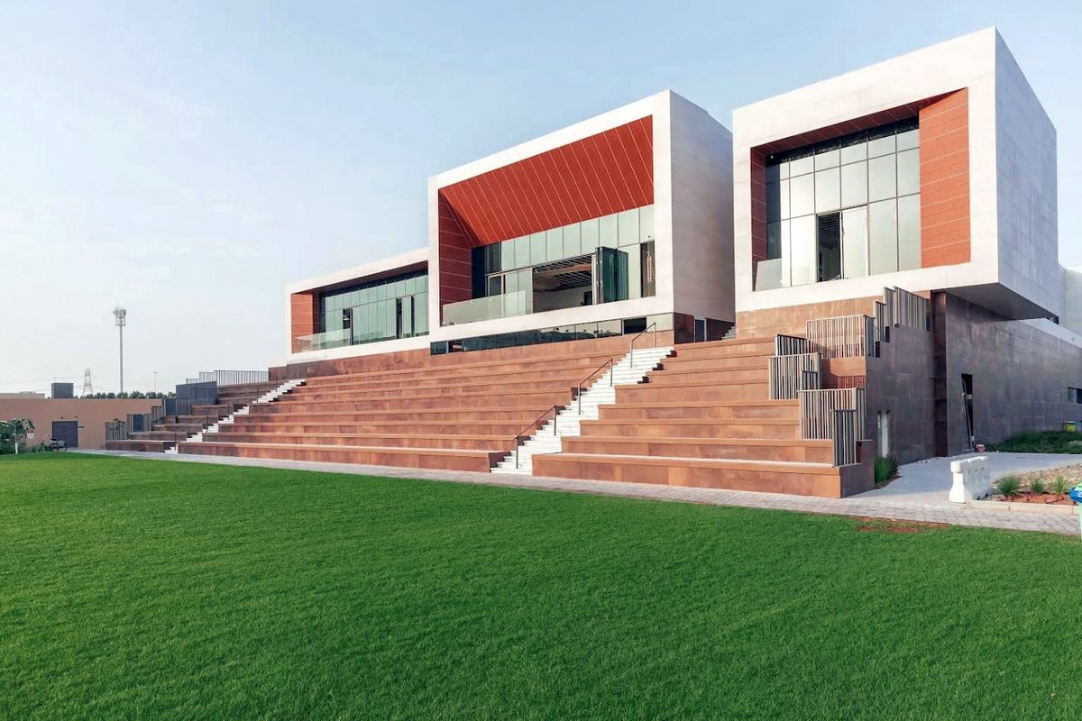 SEE Institute, a low white and terracotta building above a wide flight of terraced steps and a green lawn